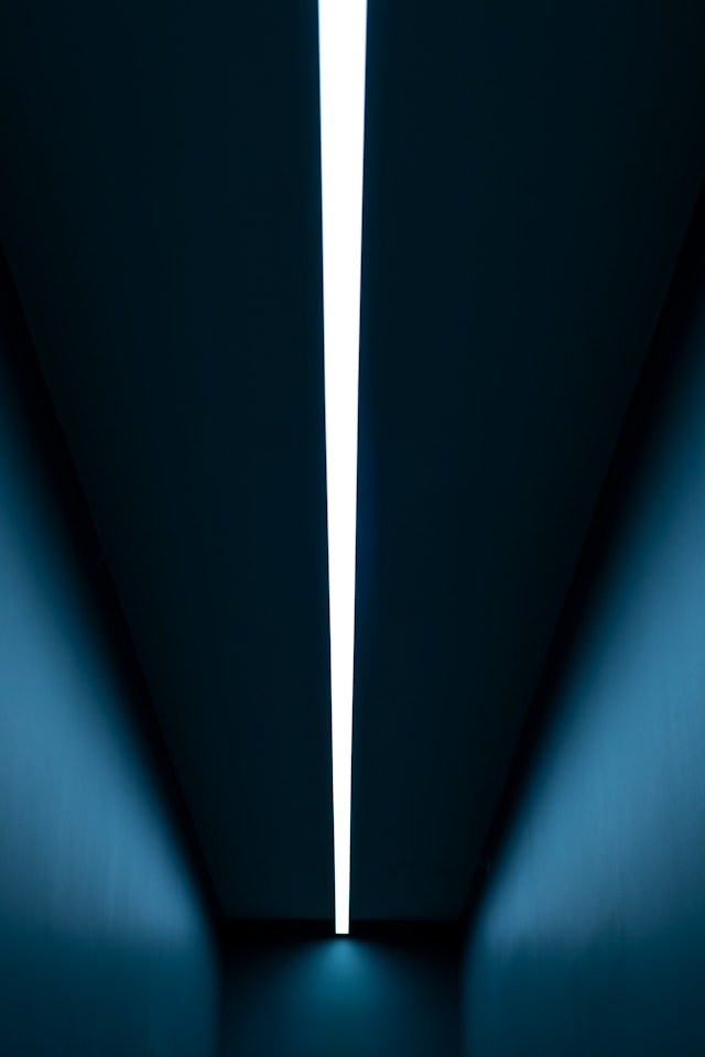 Patentability analysis, prior art search tools testimonial, image of white strip light, blue corridor